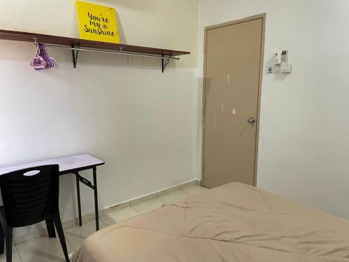 a room with a bed and a table and a door at Kuza Homes Batu Berendam in Melaka