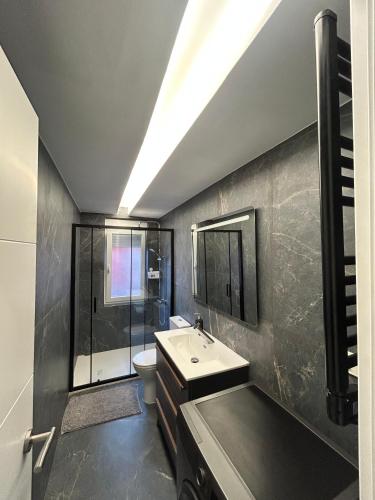 a bathroom with a sink and a shower and a toilet at Apartamento de la playa VUT 7012 AS in San Juan de Nieva