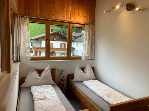 two beds in a room with two windows at Ferienwohnung Thurntaler in Sillian