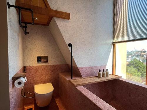a bathroom with a tub and a toilet and a window at The Pink Boutique Hotel in Da Lat