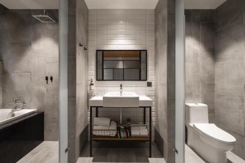 a bathroom with a sink and a toilet at Hotel Leisure 台南行旅-巷弄潮旅 in Tainan