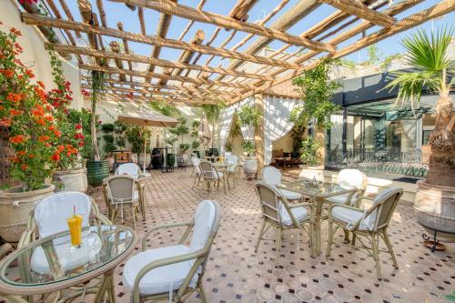 a patio with tables and chairs and plants at Palais Tara & Spa in Marrakech
