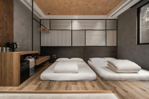 a bedroom with two beds in a room at Hotel Leisure 台南行旅-巷弄潮旅 in Tainan