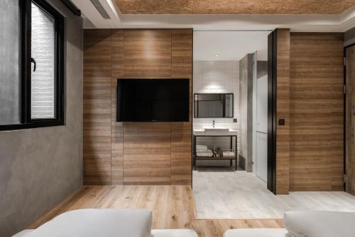 a living room with a flat screen tv on a wall at Hotel Leisure 台南行旅-巷弄潮旅 in Tainan