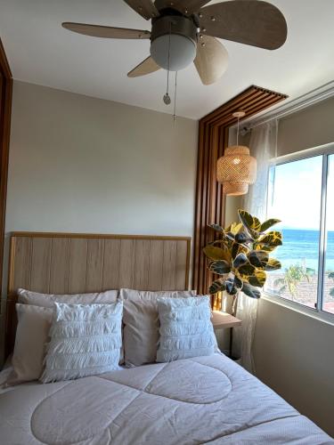 a bedroom with a bed with a ceiling fan and a window at CoNDOTEL DC in Dumaguete