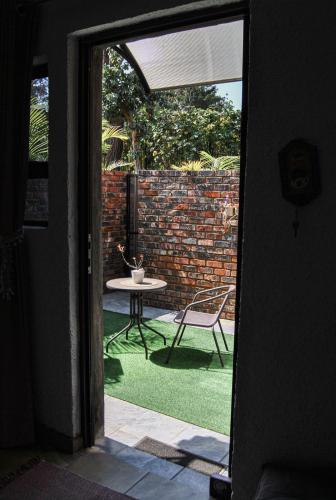 a door leading to a patio with a table and a chair at Yolandré in Rustenburg