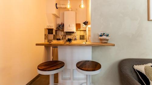 - une cuisine avec deux tabourets et un comptoir avec un évier dans l'établissement Le nid - Hypercentre Dijon, à Dijon