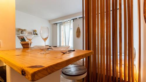 - une table en bois avec 2 verres à vin dans l'établissement Le nid - Hypercentre Dijon, à Dijon