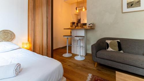 une chambre avec un lit, un canapé et une chaise dans l'établissement Le nid - Hypercentre Dijon, à Dijon