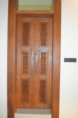a wooden door with patterns on it in a room at Madiha Venus in Matara