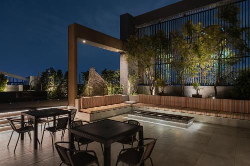 a patio with two tables and chairs and a pool at Hotel Leisure 台南行旅-巷弄潮旅 in Tainan