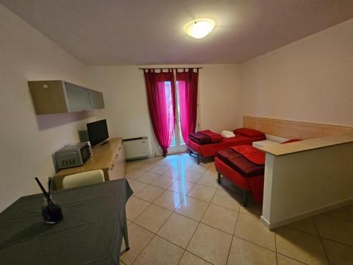 a living room with a red couch and a table at Casa vacanze 7 in Pescincanna