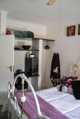 a bedroom with a bed with a purple blanket at Yolandré in Rustenburg
