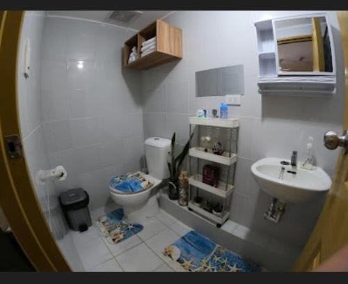 a small bathroom with a toilet and a sink at CoNDOTEL DC in Dumaguete