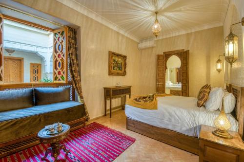 a bedroom with a bed and a couch and a mirror at Palais Tara & Spa in Marrakech