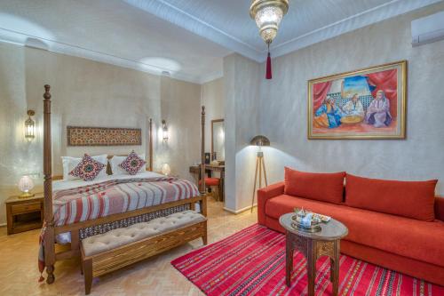 a bedroom with a bed and a red couch at Palais Tara & Spa in Marrakech
