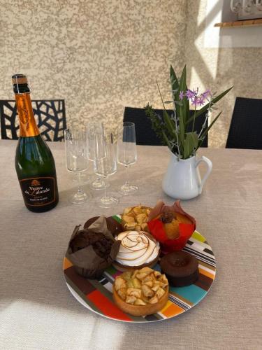 a plate of food on a table with a bottle of wine at Village villa, private pool, canal du midi in Argens Minervois