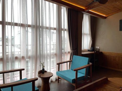 a room with a blue chair in front of a window at The Pink Boutique Hotel in Da Lat