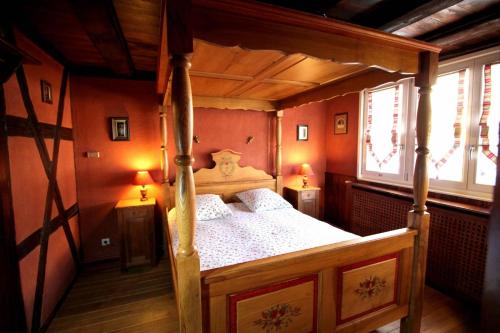 une chambre avec un lit en bois dans une pièce dans l'établissement Gîte des Amoureux, à Colmar