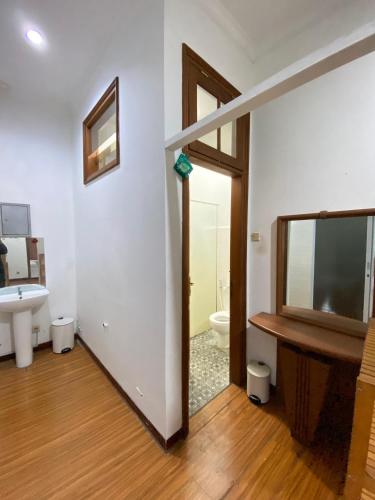 a bathroom with a sink and a toilet and a mirror at Bimo Inn Malioboro in Jetis