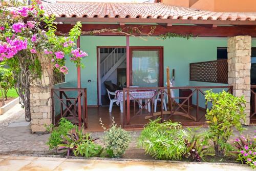 a house with a patio with a table and chairs at Porto Antigo II Poolside Appartment in Santa Maria