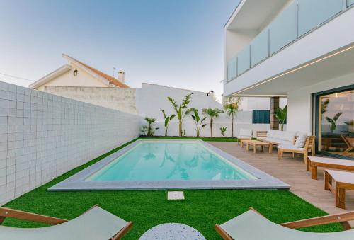 ein Swimmingpool im Hinterhof eines Hauses in der Unterkunft Botánica by Caparica Experience in Charneca