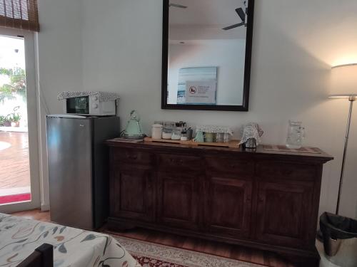 a kitchen with a wooden cabinet and a refrigerator at Rumah Putih B&B near KLIA in Sepang