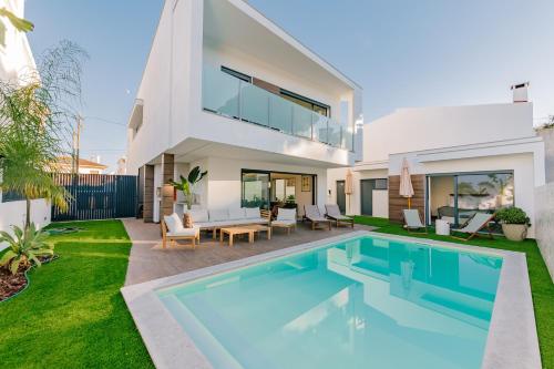 ein Bild von einem Haus mit einem Swimmingpool in der Unterkunft Botánica by Caparica Experience in Charneca