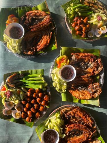 a table topped with plates of food with different foods at Besañes Homestay in Alaminos