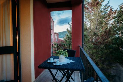 a table on a balcony with two mugs and a plant at Residence Stella Dell'Est in Bari Sardo