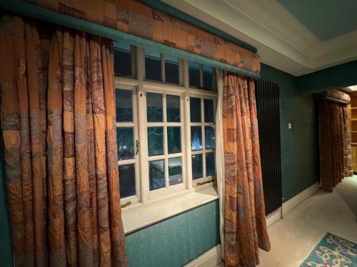 a window in a room with curtains on a wall at The Bishop in London