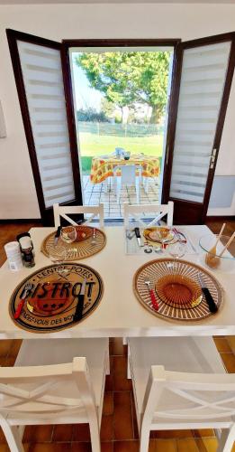 une table blanche avec des chaises et des assiettes dessus dans l'établissement 