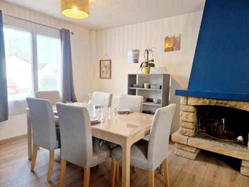 une salle à manger avec une table et une cheminée dans l'établissement Les Oyats, aux Pieux