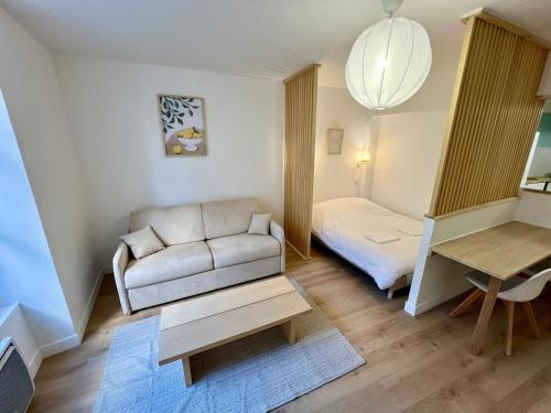 un salon avec un canapé et une table dans l'établissement Large bright studio, à Poitiers