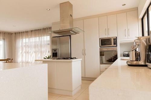 a kitchen with white cabinets and a stove top oven at Heated magnesium pool, MTB, family & dog friendly in St Helens