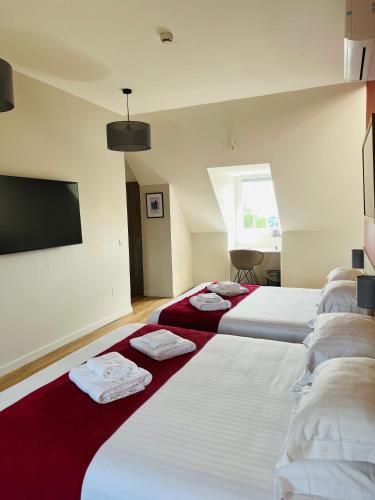 une rangée de lits dans une chambre d'hôtel dans l'établissement Le Domaine du Golf Country Club de Bigorre, à Pouzac