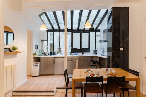 une salle à manger et une cuisine avec une table et des chaises dans l'établissement Saint germain sartre apartment, à Paris