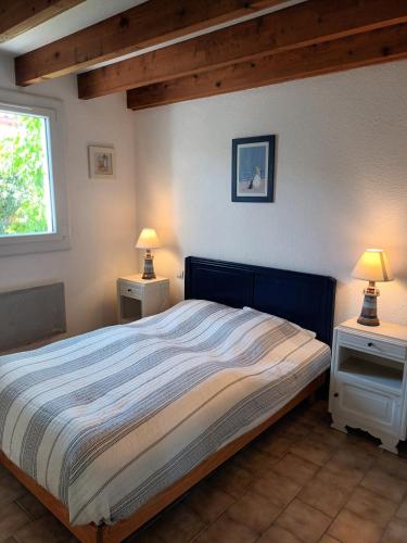 een slaapkamer met een groot bed met twee nachtkastjes bij Le clos de la Galiote in Saint-Pierre-dʼOléron