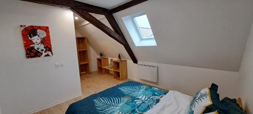 Cette petite chambre mansardée comprend un lit et une fenêtre. dans l'établissement Le Coin Zen, à Bergheim