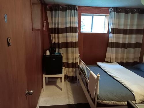 a small bedroom with a bed and a window at Burnaby house by New Westminster in Burnaby
