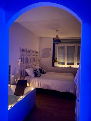 a bedroom with two beds and a blue light at Les Secrets de la Baie - l'Archipel - cocon bien-être avec Spa et Sauna in Étaples