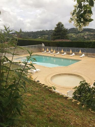 une piscine avec des chaises longues et un tas de meubles dans l'établissement Le N4 des Hauts de SARLAT, Clim Piscine Parking, à Sarlat-la-Canéda