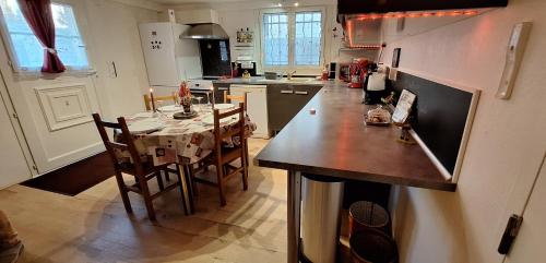 une cuisine avec une table et des chaises dans une cuisine dans l'établissement Superbe T2 avec jardin, piscine-enfant et parking, à Arles