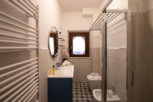 a bathroom with a sink and a toilet and a mirror at CADEMU Camaga in LʼAquila