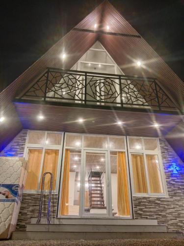 a house with a balcony on top of it at Pine Trees Gold in Vagamon