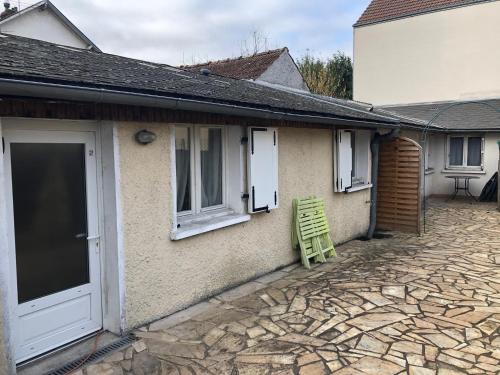 une chaise verte assise à l'extérieur d'une maison dans l'établissement Charmant studio proche centre ville d’Orléans, à Orléans