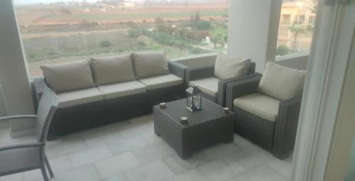 a living room with a couch and chairs and a window at appartment &Roof top duplex with solarium in Bouznika