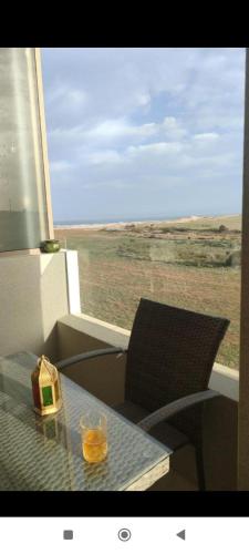 a glass on a table with a view of the desert at appartment &Roof top duplex with solarium in Bouznika