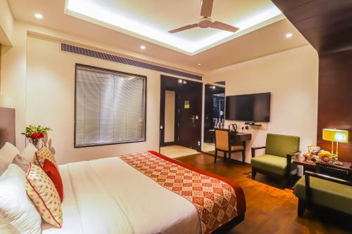 a bedroom with a bed and a desk and a chair at Hotel Godwin Deluxe - Free Airport Pick-Up in New Delhi