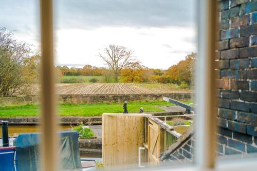 a window with a view of a field with a statue at Belvedere House - Serene Countryside Escape - 4 Bedrooms Sleeps 8 in Wheelock